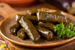 Dolmas grape leaves on a brown handled dish